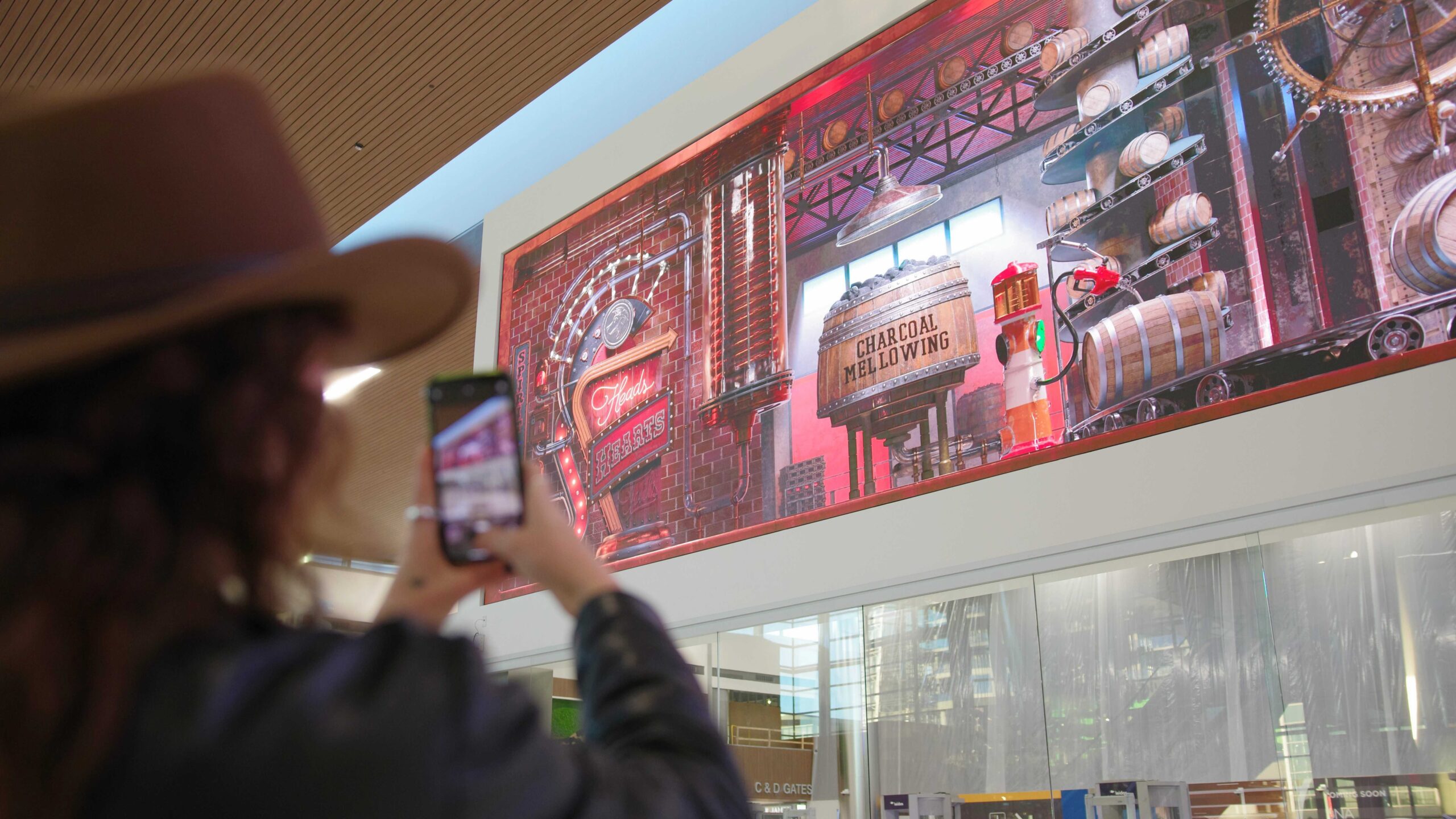 A woman takes a picture with her phone of the Nashville Airport's brand new Grand Lobby.