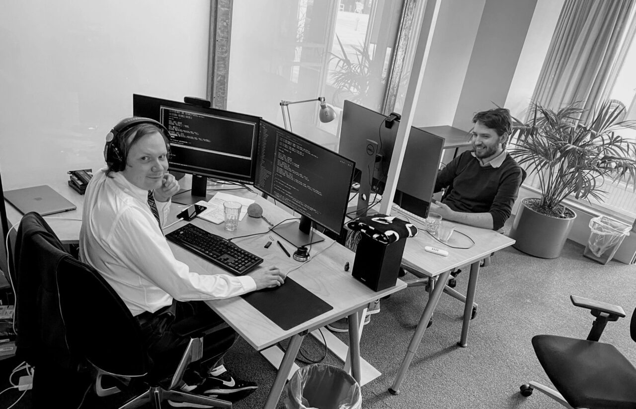 Core Blender members and main engineers Sergey Sharybin and Brecht Van Lommel, sitting ar their desks, working on Cycles X.